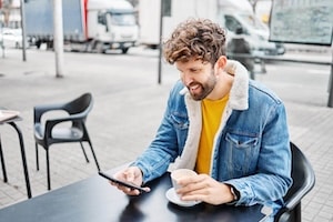 Man drinking coffee with mobile phone