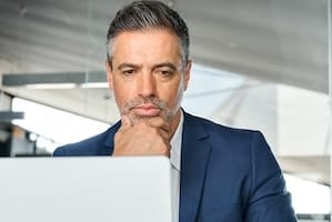 Concerned busy business man ceo executive manager looking at laptop thinking.