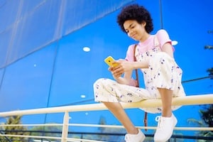 Content black woman texting message on fence