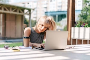 serious-thinking-woman-working-at-laptop-outside