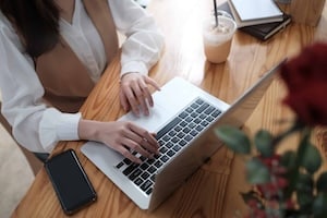 Top view businesswoman typing laptop computer on her table.