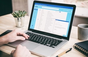 Coach preparing email newsletter to maintain client relationships