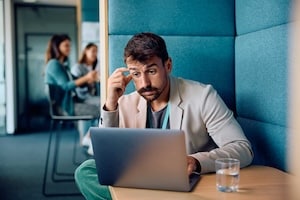 Thoughtful businessman using laptop while working in the office.