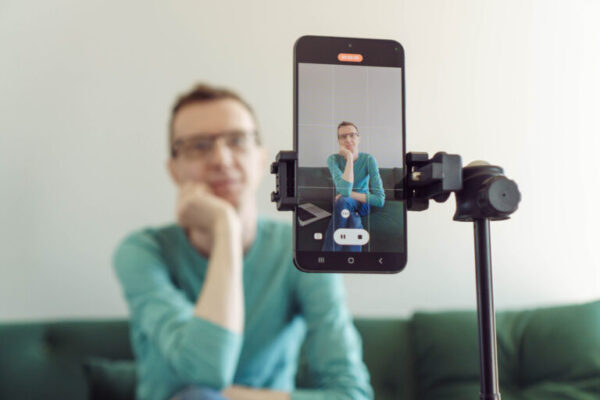 Digital content creator filming video with smartphone on tripod