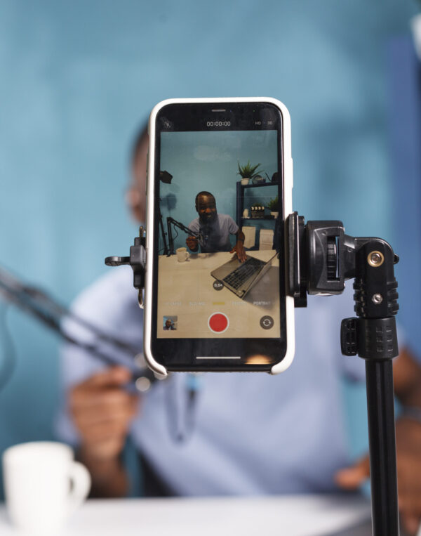 Podcaster recording video using smartphone and tripod