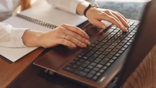 Close-up of hands typing on a laptop during a website audit