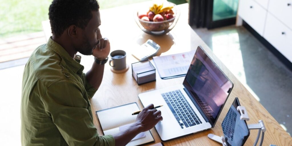 Business professional auditing website for trust signals at laptop
