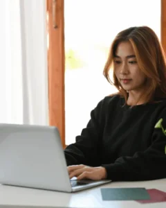 Entrepreneur testing different email formats on her laptop
