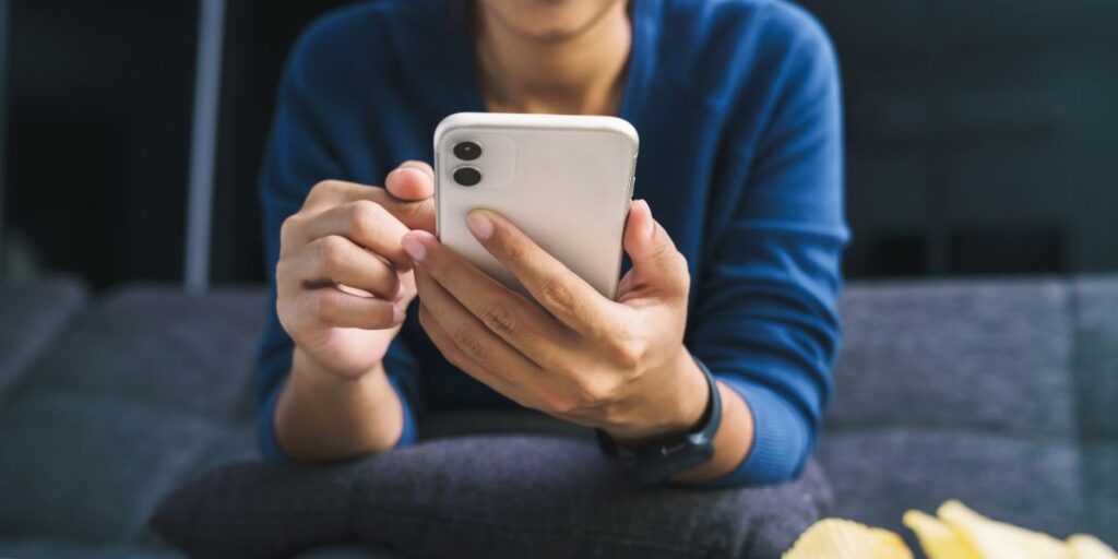 Small business owner using a smartphone to search local services, showing how local SEO in 2025 drives nearby customers to find businesses online.