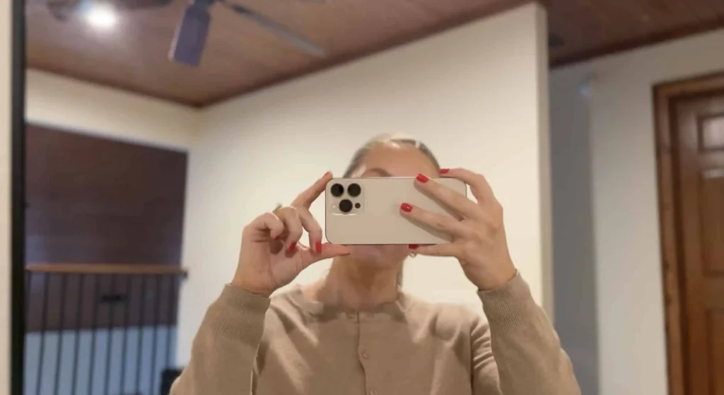 Woman taking a selfie with a smartphone, symbolizing personal branding and online reputation building in 2026