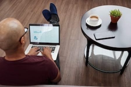 Entrepreneur sitting on the floor next to coffee table and working on monthly financial report