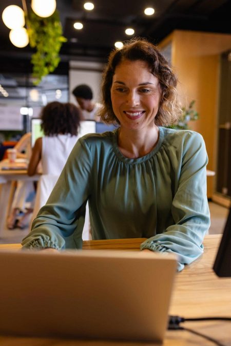 Happy caucasian casual businesswoman using laptop in office. Casual office, business, communication and work, unaltered. marketing-budget