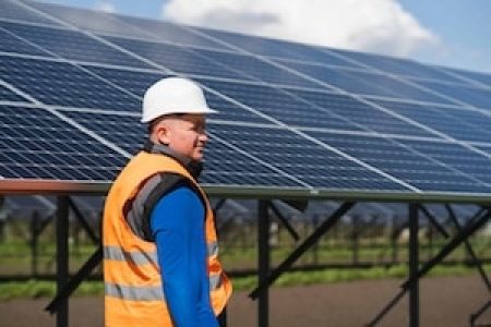 Male worker in hard hat at a solar power plant a