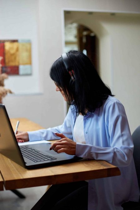 Mature old lady wearing headphones, study online education training marketing-budget