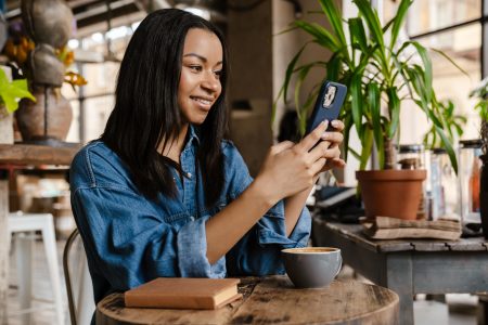 Smiling young african woman using mobile phone content-marketing-trend