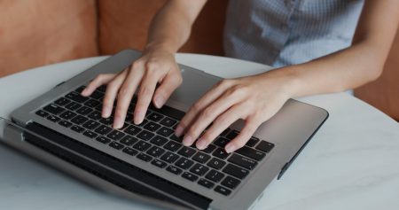 Woman types on laptop computer at home co-created content